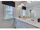 Double vanity bathroom with a large mirror and window at 109 Magma Ln, Holly Springs, NC 27540