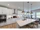 Modern kitchen with white cabinets, island, and stainless steel appliances at 109 Magma Ln, Holly Springs, NC 27540