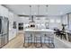 Modern kitchen with white cabinets, island, and stainless steel appliances at 109 Magma Ln, Holly Springs, NC 27540