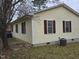 Rear view of a house with yellow siding, maroon shutters and central AC unit at 1102 E Ellerbee St, Durham, NC 27704