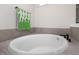 Elegant bathroom with soaking tub, gray cabinets, and modern fixtures at 120 Rider Race Bnd, Holly Springs, NC 27540