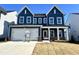 Two-story home with blue siding, white garage door, and landscaping at 121 S Stonemill Trl # Homesite 240, Clayton, NC 27520