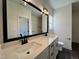 Bathroom featuring a double sink vanity, a large mirror, and modern lighting fixtures at 137 Pretty Run Branch Ln, Wendell, NC 27591