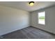 Minimalist bedroom featuring neutral walls, carpeted floor, and a window providing natural light at 137 Pretty Run Branch Ln, Wendell, NC 27591