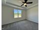 Cozy bedroom with a tray ceiling, ceiling fan, carpeted floor, and a window with a view at 137 Pretty Run Branch Ln, Wendell, NC 27591