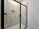 Modern walk-in shower with tiled walls, a glass door, and black trim at 137 Pretty Run Branch Ln, Wendell, NC 27591