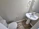 Clean powder room with pedestal sink and wood-look tile floor at 1527 Haywards Heath Ln, Apex, NC 27502