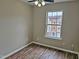 Well-lit bedroom with wood-look floors and window at 1527 Haywards Heath Ln, Apex, NC 27502