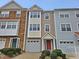 Three-story townhome with stone and siding, two-car garage, and landscaping at 1527 Haywards Heath Ln, Apex, NC 27502