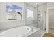 Modern bathroom features a large soaking tub, glass shower, and large window with views at 292 Weddington Way, Benson, NC 27504