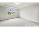 Bright bedroom featuring large window, plush carpeting, tray ceiling, and neutral paint at 292 Weddington Way, Benson, NC 27504