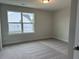 Neutral bedroom with a large window providing natural light and plush carpeting creating a cozy atmosphere at 292 Weddington Way, Benson, NC 27504