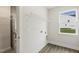 New laundry room with wood-look floors, shelving, hookups, and a window at 292 Weddington Way, Benson, NC 27504