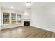 Bright living room featuring a fireplace, hardwood floors, and three large windows at 292 Weddington Way, Benson, NC 27504