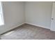 Bedroom showcasing neutral paint, plush carpet, base trim, and ample natural light from a large window at 308 Whispering Way, Sanford, NC 27330