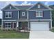 Stylish two-story home with a two-car garage, stone accents, manicured lawn and colorful shutters at 308 Whispering Way, Sanford, NC 27330