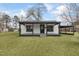 White house with black trim, covered porch, and a spacious yard at 521 Mill St, Smithfield, NC 27577