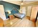 Bedroom with hardwood floors, ceiling fan, and accent wall at 5718 Sentinel Dr, Raleigh, NC 27609