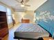 Bedroom with hardwood floors, ceiling fan, and accent wall at 5718 Sentinel Dr, Raleigh, NC 27609