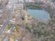 Aerial view showcasing the home's position near a tranquil lake and wooded area at 802 S Sellars Mill Rd, Burlington, NC 27217