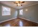 Spacious bedroom with hardwood floors, ceiling fan, and two windows at 802 S Sellars Mill Rd, Burlington, NC 27217