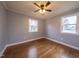 Bright bedroom with hardwood floors, ceiling fan, and two windows at 802 S Sellars Mill Rd, Burlington, NC 27217