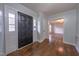 Bright entryway with hardwood floors and dark front door leading to living room at 802 S Sellars Mill Rd, Burlington, NC 27217