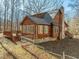 Rustic log home with stone accents, deck, and wooded backdrop at 1018 Christy Ridge Ct, Rougemont, NC 27572