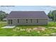 Back exterior showcasing sliding glass door, multiple windows, and grassy backyard at 121 Tanglewood Dr # 8-J, Louisburg, NC 27549