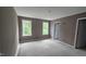 This is a bedroom with two windows, neutral colored walls, and unfinished flooring at 121 Tanglewood Dr # 8-J, Louisburg, NC 27549