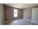 This bedroom features neutral carpet and a window providing natural light to the calming colored walls at 121 Tanglewood Dr # 8-J, Louisburg, NC 27549
