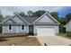 Charming single-story home with light blue siding, black roof, and a two car attached garage at 121 Tanglewood Dr # 8-J, Louisburg, NC 27549