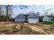 Newly constructed home with blue siding, a two-car garage, and a partially landscaped yard at 121 Tanglewood Dr # 8-J, Louisburg, NC 27549