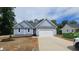 Charming single-story home with light blue siding, black roof, and a two car attached garage at 121 Tanglewood Dr # 8-J, Louisburg, NC 27549