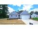 Charming one-story home with blue siding, a two-car garage, and a well-maintained lawn on a sunny day at 121 Tanglewood Dr # 8-J, Louisburg, NC 27549