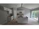 Bright kitchen with white cabinetry, island, and sliding glass doors to the backyard at 121 Tanglewood Dr # 8-J, Louisburg, NC 27549