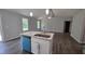 Open kitchen with an island with a sink and dishwasher, white cabinets, and hardwood floors at 121 Tanglewood Dr # 8-J, Louisburg, NC 27549