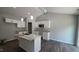 Bright kitchen featuring white cabinets, modern appliances, and a stylish island with granite countertops at 121 Tanglewood Dr # 8-J, Louisburg, NC 27549
