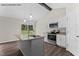 Bright kitchen featuring white cabinetry, granite countertops, stainless appliances, and an island with seating at 121 Tanglewood Dr # 8-J, Louisburg, NC 27549