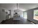 Open-concept living room and kitchen area with island, modern cabinets, and a door to an outside patio at 121 Tanglewood Dr # 8-J, Louisburg, NC 27549