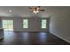 Open living room featuring hardwood floors, two large windows, and sliding glass doors to the deck at 121 Tanglewood Dr # 8-J, Louisburg, NC 27549