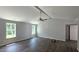 Bright living room with dark hardwood flooring and a modern ceiling fan with an architectural beam at 121 Tanglewood Dr # 8-J, Louisburg, NC 27549