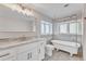 Elegant bathroom with a clawfoot tub, granite countertop, and gold fixtures at 126 Person St, Louisburg, NC 27549