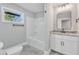 Updated bathroom with white vanity, granite countertop and tub at 126 Person St, Louisburg, NC 27549