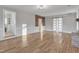 Bright living room featuring hardwood floors, brick accent wall, and barn door at 126 Person St, Louisburg, NC 27549