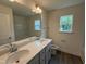 Bathroom featuring a double vanity with quartz countertop, white cabinets, and a shower-tub combo at 129 Stallion Way, Benson, NC 27504