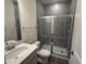Modern bathroom featuring a tiled shower, stylish vanity with gray cabinets, and quartz countertop at 129 Stallion Way, Benson, NC 27504