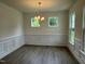 Bright dining room featuring elegant wainscoting, modern lighting, and beautiful wood flooring at 129 Stallion Way, Benson, NC 27504