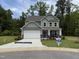 Charming two-story home with gray siding, a two-car garage, and a well-manicured lawn at 129 Stallion Way, Benson, NC 27504