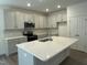 Modern kitchen with stainless steel appliances, gray cabinets, an island, and white marble backsplash at 129 Stallion Way, Benson, NC 27504